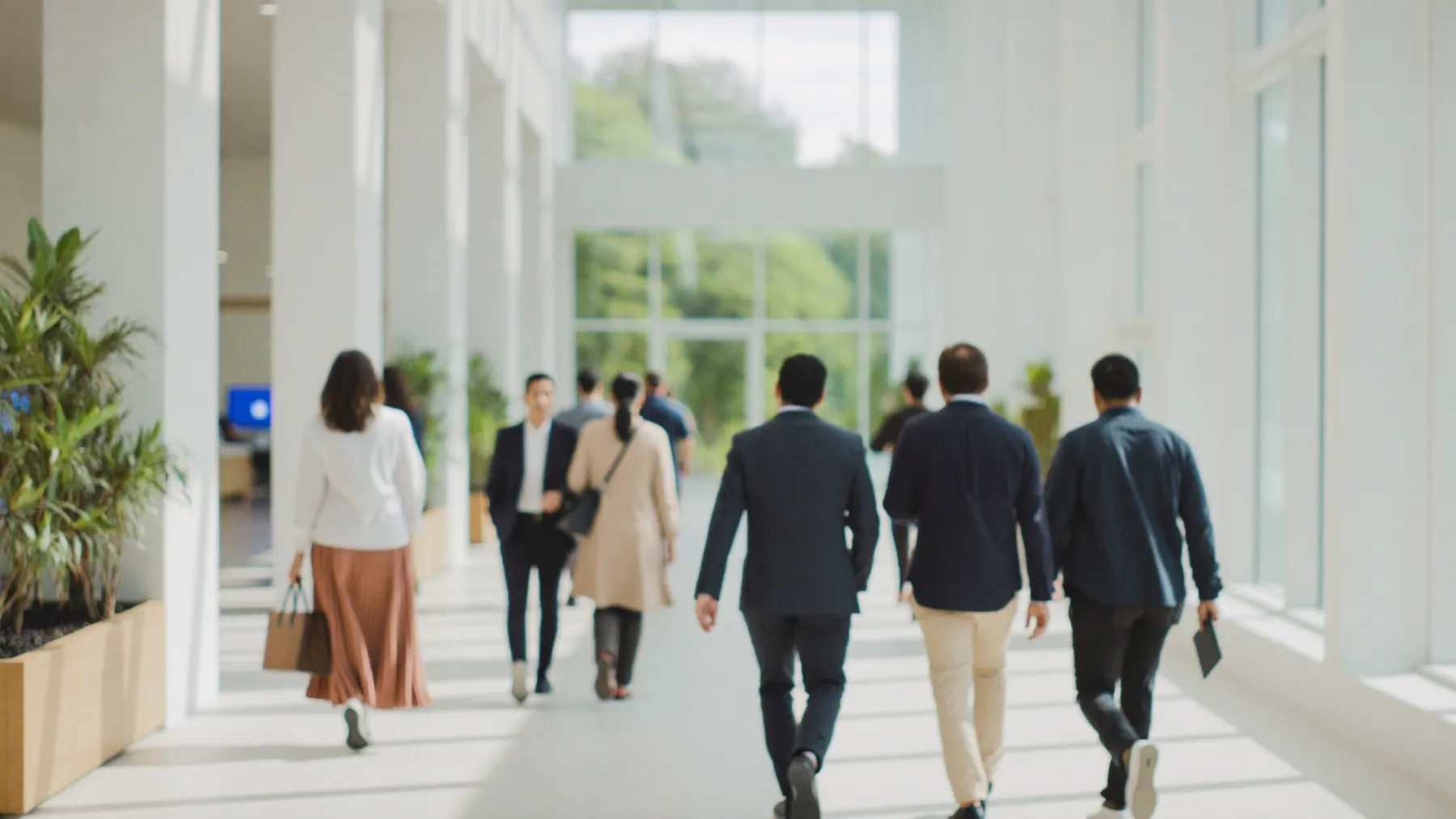 Professionals walking through the bright atrium of a large office building