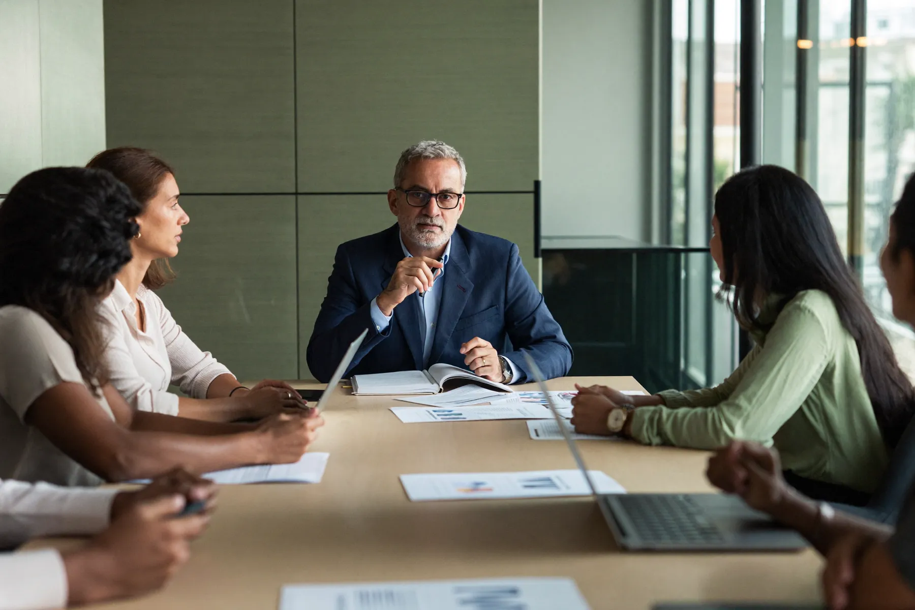 Senior leaders in a focused board meeting around a table